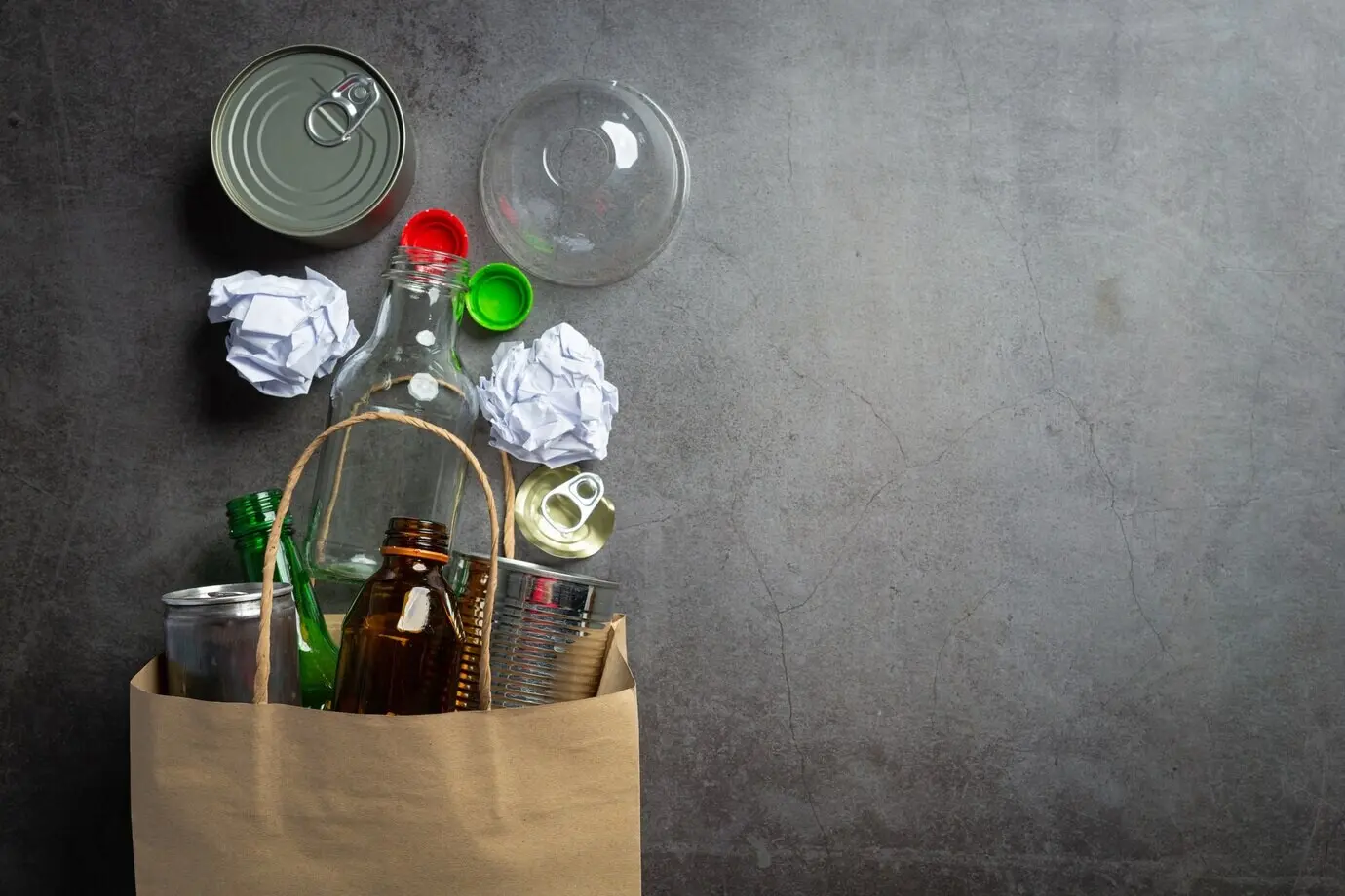 На тёмном полу собралось много видов мусора.